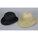 A Dunn & Co. of London black felt bowler hat; & a pith helmet.