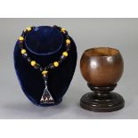 A bead necklace having triangular beadwork pendant (possibly Turkish); & a 19th century coconut cup,