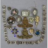 An engraved white-metal oval photograph locket; three white-metal brooches; various items of costume