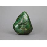 A polished green stone boulder carved with a face, 5½” high.