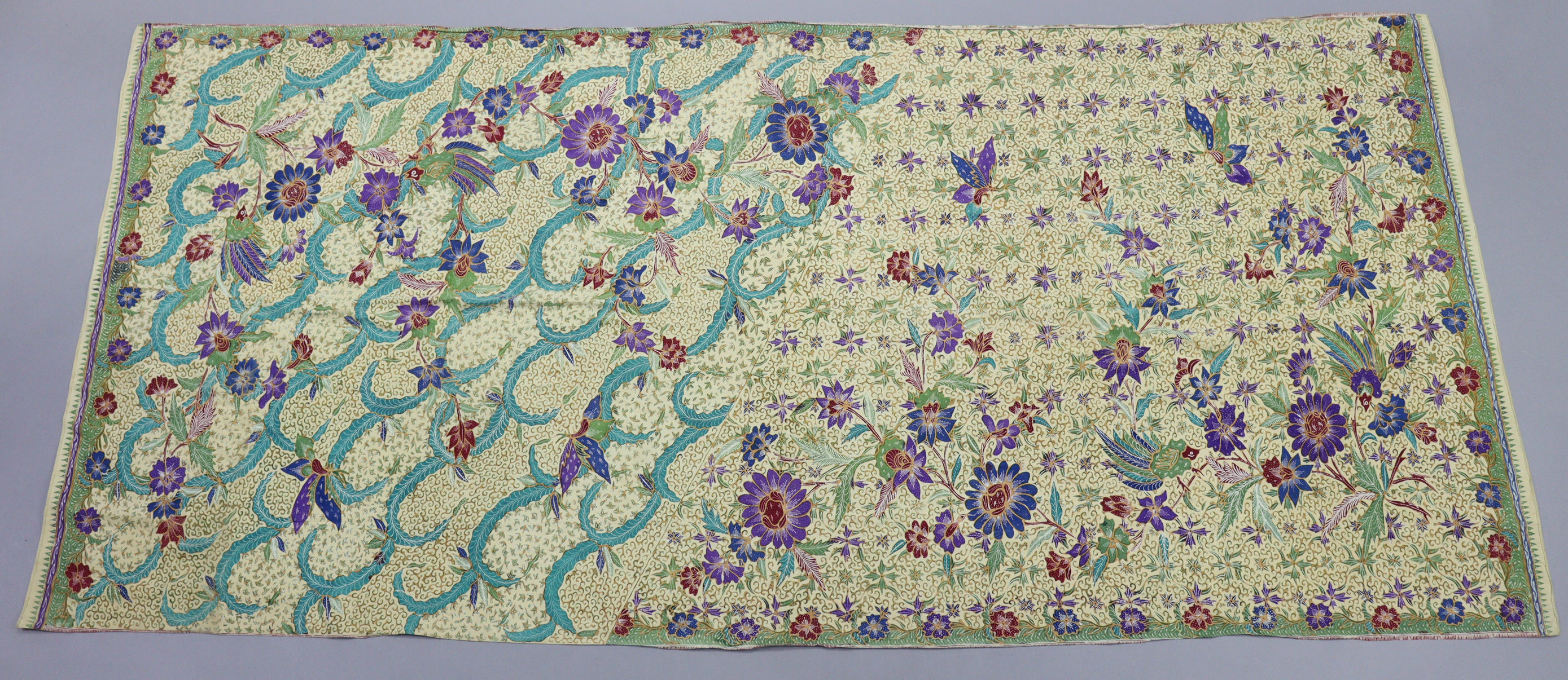 A 1930’s batik, of cream ground with all-over repeating multicoloured geometric & foliate design;
