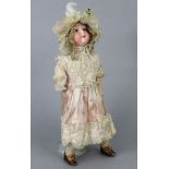 An Armand Marseille bisque-head girl doll (246/1) a 2½/M), lacking one hand, 17½” tall, dressed.