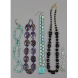 A simulated jade necklace; an amethyst necklace; & two other necklaces.