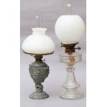 A late Victorian clear glass oil lamp with faceted flared stem; & a speltre oil lamp; each with