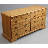A pine low chest fitted two ranks of three long graduated drawers, 50” wide x 26” high x 16” deep.