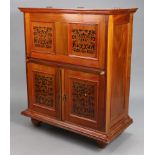 An eastern hardwood drinks cabinet enclosed by a hinged lift-lid & fall-front above a cupboard