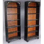 A pair of modern black & gold painted tall standing six-tier open bookcases, each on bracket feet,