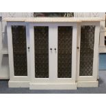 A white & cream painted wooden break-front radiator cover with moulded edge enclosed by two pairs of