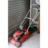 A Mountfield petrol-driven lawnmower with grass box.