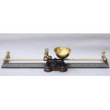 A cast-iron fender with a brass rail gallery & foliate decoration, 51½” long; together with a set of