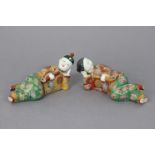 A pair of early 20th century Chinese porcelain models of reclining male & female figures, each