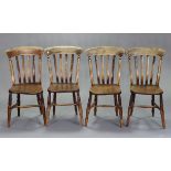 A set of four Windsor style lath-back dining chairs with hard seats & on ring-turned legs with H-