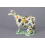 An early 19th century English pottery cow creamer with sponge decoration, modelled with a milk