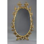 A George III style oval will mirror in carved & pierced giltwood foliate frame, 46” x 27”.