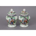 A pair of Chinese porcelain small baluster vases & covers, each decorated in famille verte enamels
