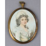 A 19th century head-&-shoulders oval portrait miniature of a lady wearing pale green blouse & silk