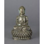 An oriental white metal figure of a Buddhistic deity, seated on double lotus base, 5½” high.