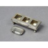 An Edwardian silver three-division postage stamp box, the trough-shaped base on four ball feet,