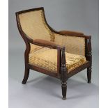 A regency mahogany frame bergère with shaped square back, padded arms & loose cushion seat, on