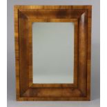 A rectangular wall mirror in cushion moulded walnut frame, 27” x 21”.