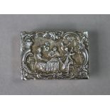 A silver rectangular pill box with scene of an 18th century quintet to the hinged cast lid, 1¾”