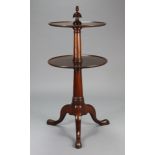 A George III mahogany circular two-tier dumb waiter with tapered gun-barrel columns, shaped