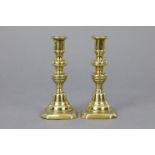 A pair of 19th century brass small tapersticks, each on turned column & square platform base, 5”