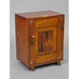 A Japanese hardwood small cupboard fitted with a centre shelf enclosed by a panel door, 11¾” wide