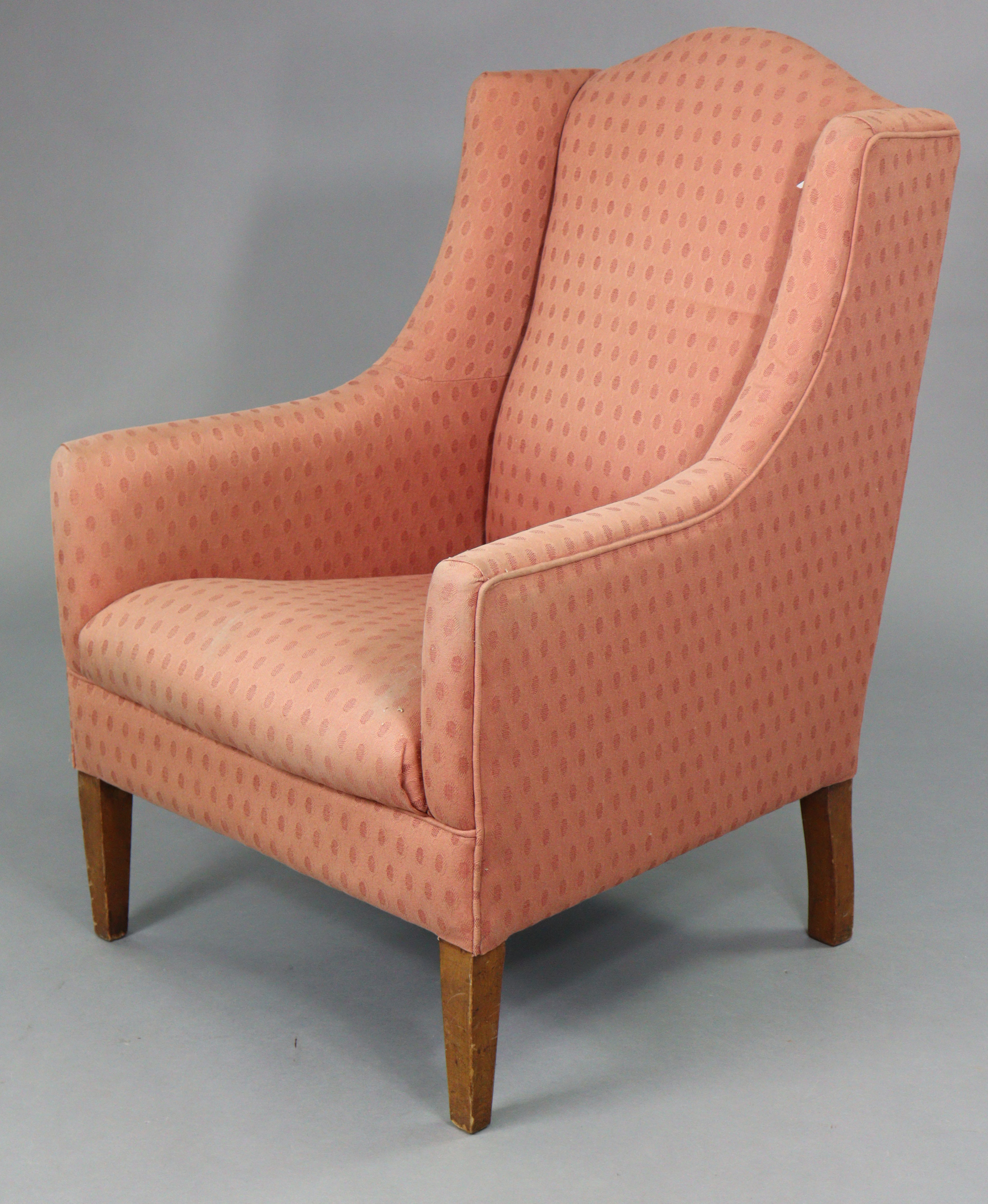 An Edwardian armchair with rounded back & sprung seat upholstered pink geometric material, & on