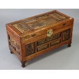 A Chinese-style small carved camphor wood chest with a hinged lift-lid, & on short cabriole legs,