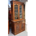 A Victorian walnut tall bookcase the upper part with four adjustable shelves enclosed by a pair of