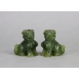 A pair of Chinese small carved jade temple-dog ornaments, 2¼” high.