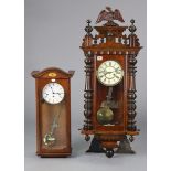 A Vienna-type wall clock with black roman numerals to the cream enamel dial, & in a glazed walnut