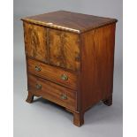 A Georgian mahogany small cabinet enclosed by a pair of panel doors above two long drawers, & on