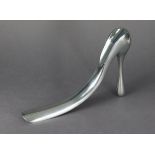 A Manolo Blahnik silvered-metal novelty shoe-horn in the form of a ladies’ shoe, 7½” high x 11”