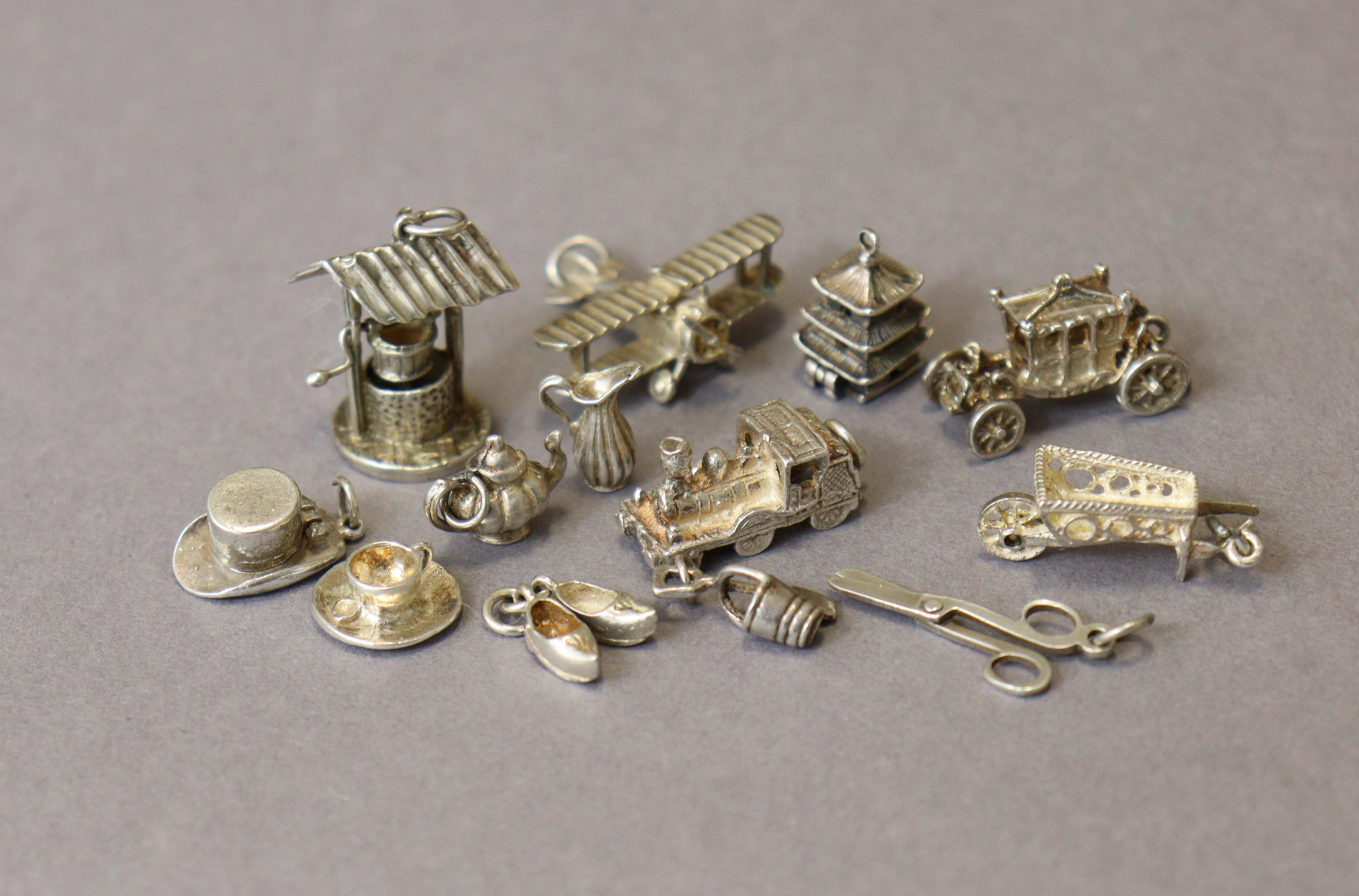 Thirteen various white metal pendant charms (loose), three of which marked “silver”.