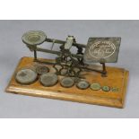 A vintage Mordan & Co. of London brass letter scale with nine brass weights, & mounted on an oak