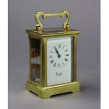 Another brass-cased carriage clock with black roman numerals to the white enamel dial, signed “
