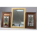 A pair of floral decorated rectangular wall mirrors each inset with a bevelled plate, & in a