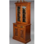 A 19th century oak tall bookcase, the upper part with three adjustable shelves enclosed by a pair of