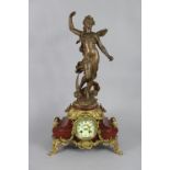 A Victorian mantel clock in gilt-metal & rouge marble case with painted dial, speltre figure of “