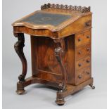 A Victorian walnut davenport with a pierced tray-top gallery above a fitted interior enclosed by a