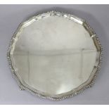 A George IV silver salver with gadrooned rim, on four claw-&-ball feet, 14” dia.; Sheffield 1936