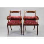 A pair of regency-style mahogany elbow chairs with brass inlay to the curved splat-backs, having