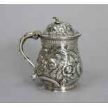 A George III silver mustard pot of baluster shape, embossed all-over with flowers & scrolls, a