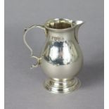 A George V silver plain baluster cream jug in the mid-18th century style, with scroll handle, on