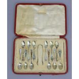 A set of twelve Sterling & coloured enamel harlequin coffee spoons & sugar tongs, by Gorham & Co.,