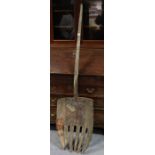 An antique wooden large pitchfork with old metal repairs, 64” long x 17” wide.