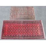 A Persian rug of madder ground with repeating geometric designs surrounded by multiple narrow