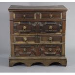 A 17th century oak chest with applied mouldings, in two sections, fitted two short & three long gra